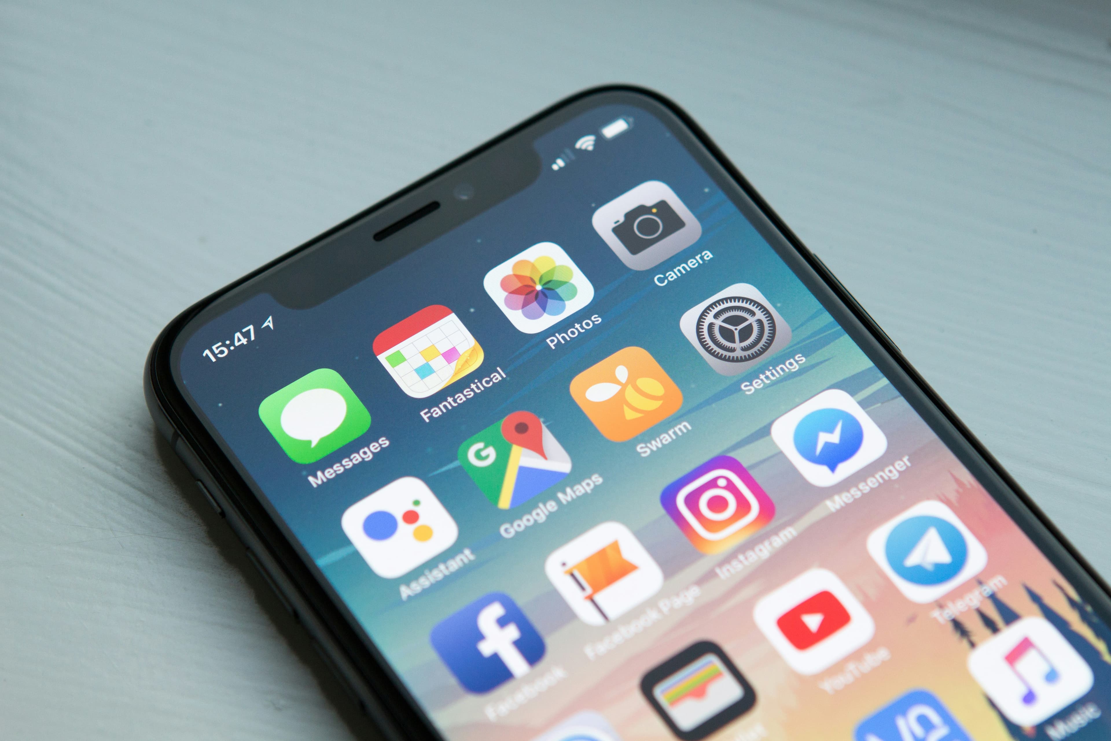 Personne qui échange par messagerie sur son téléphone dans un commerce lumineux