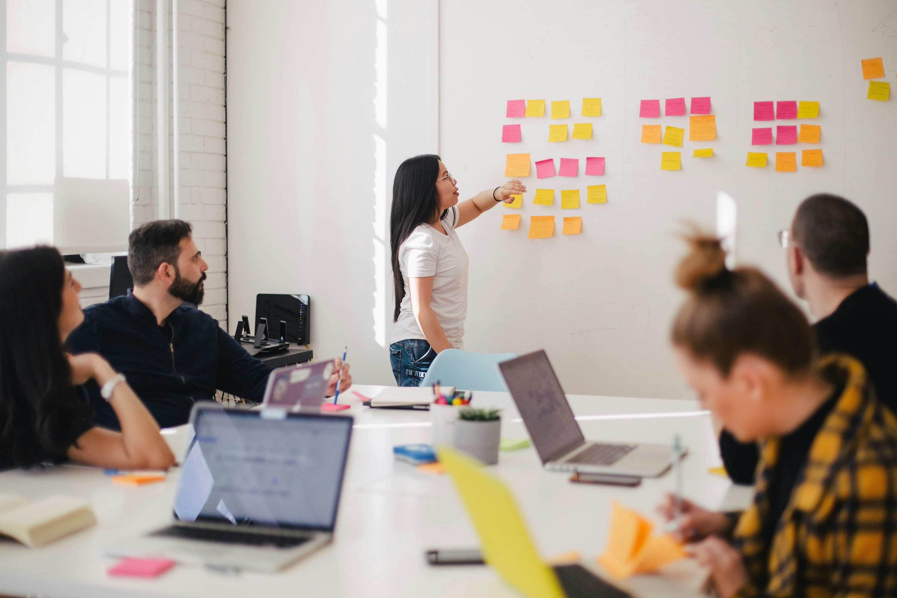 Équipe qui analyse les retours clients à l'aide de notes et de post-it au mur