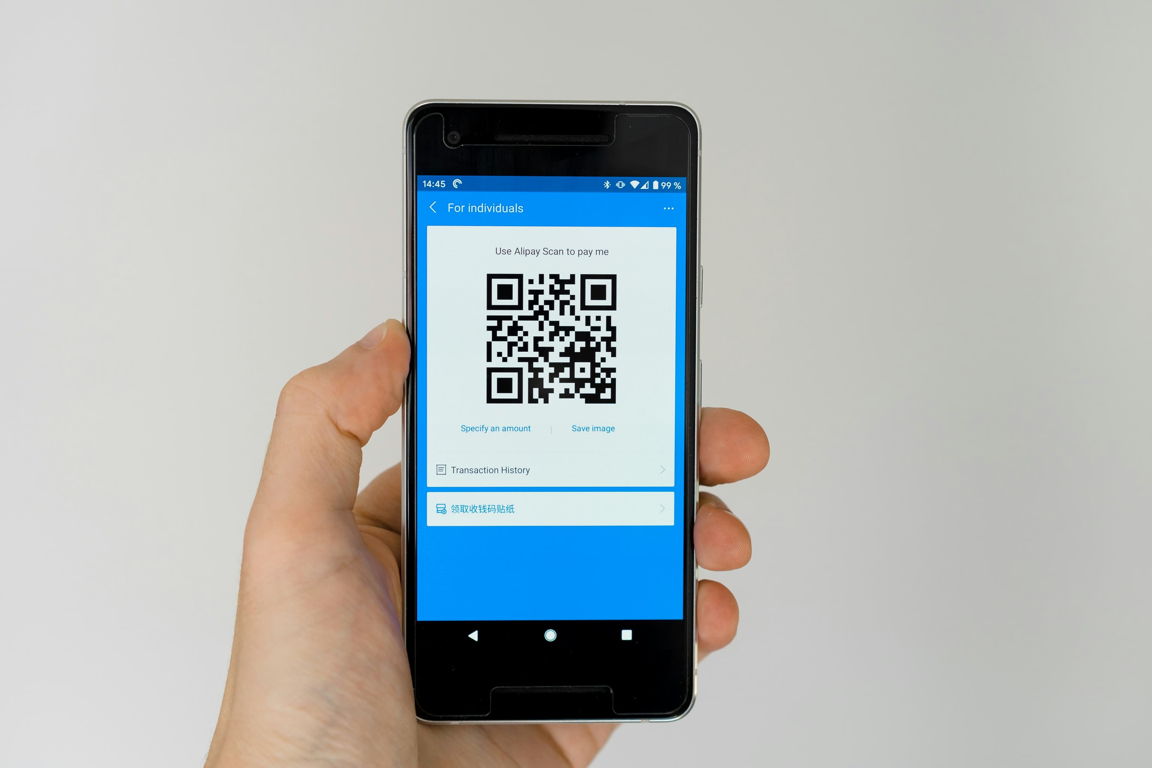 Client qui scanne un QR code posé sur le comptoir d'un commerce
